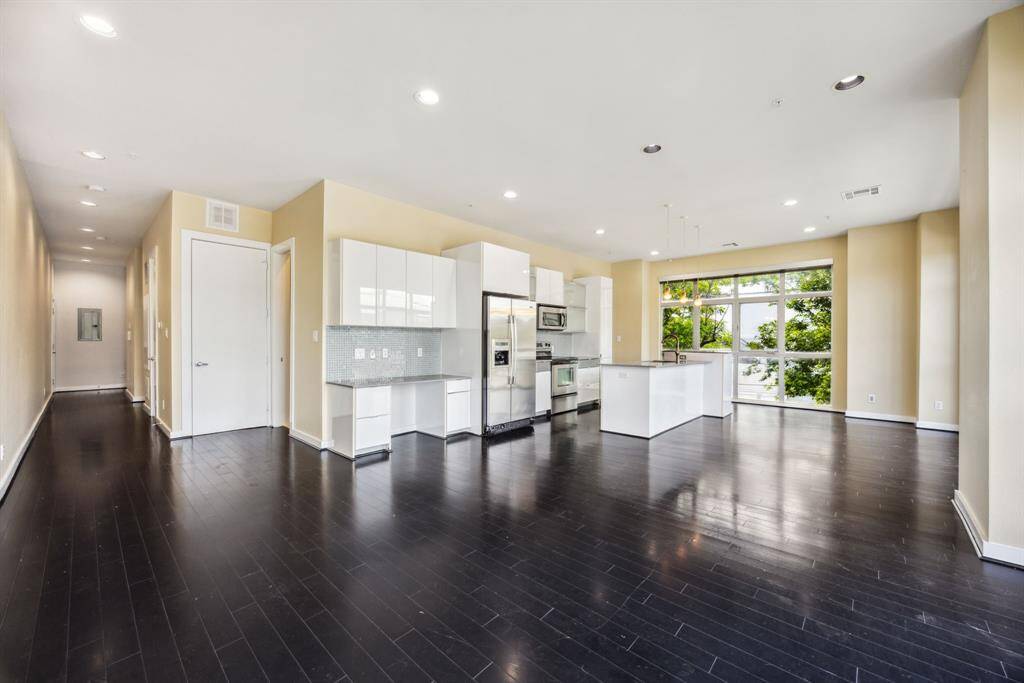Open concept room with recessed lighting and dark bamboo floors.
