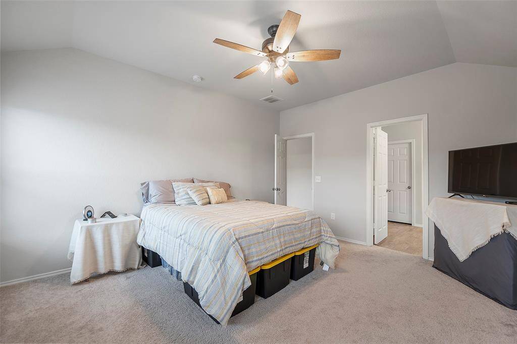 This is a bright and airy bedroom featuring soft carpeting, a ceiling fan, and ample natural light. The perfect retreat after a long day at work.