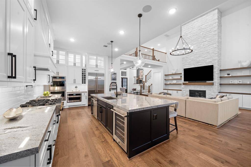 A second view of the workspace highlights dual-tone cabinetry, undercounter appliances, and expansive prep surfaces designed for real culinary performance.