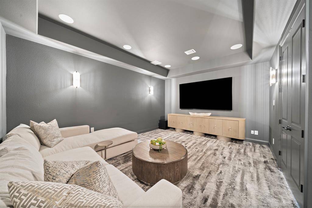 Tailored for immersive viewing, this media room features refinements like wall sconces, recessed lighting, new carpet, and a reconfigured layout that enhances comfort and screen visibility.