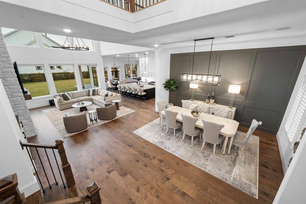 An open-concept layout showcases soaring ceilings, rich hardwood floors, and seamless transitions between the dining, living, and kitchen areas—ideal for everyday living and effortless entertaining.