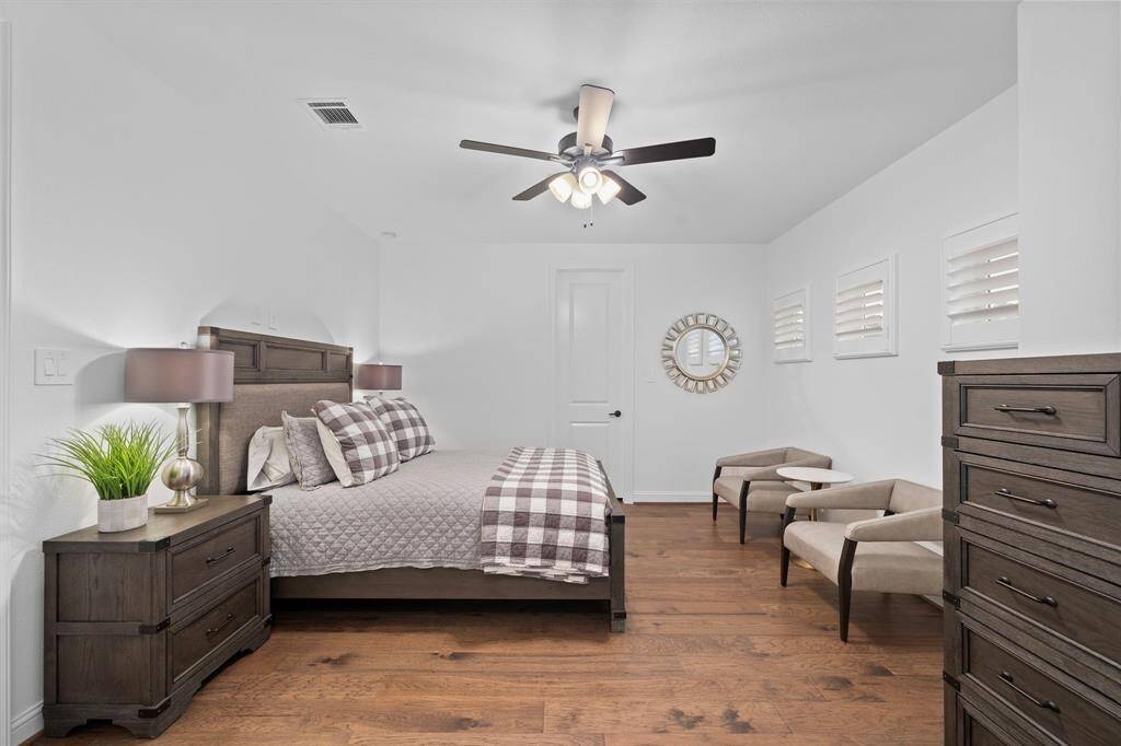 Generously sized with warm wood flooring and multiple windows, this serene guest suite offers both privacy and comfort.