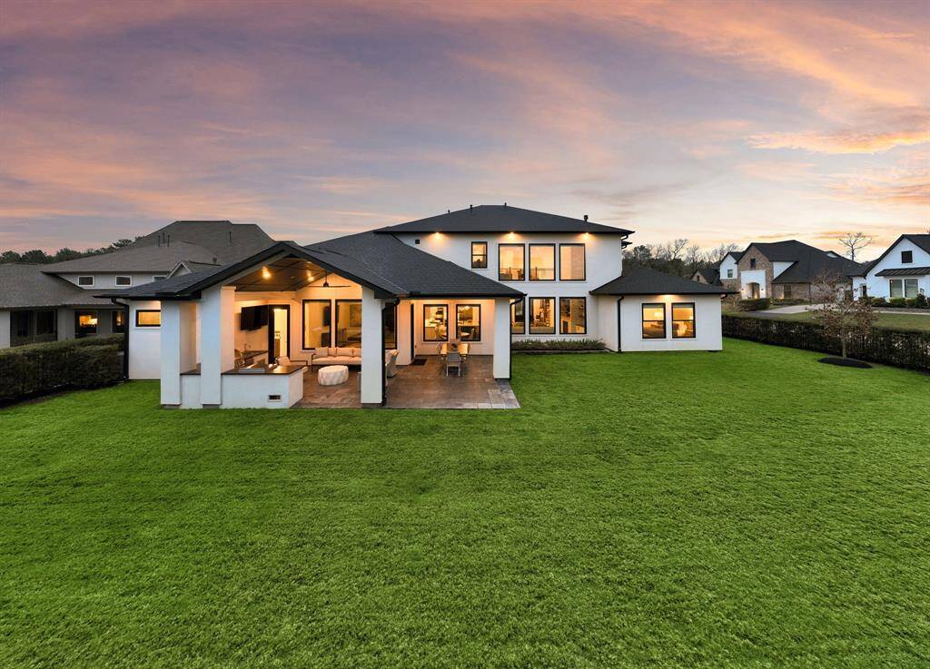 The oversized backyard frames the home with ample green space and a privacy hedge, creating a versatile setting for recreation or future enhancements.