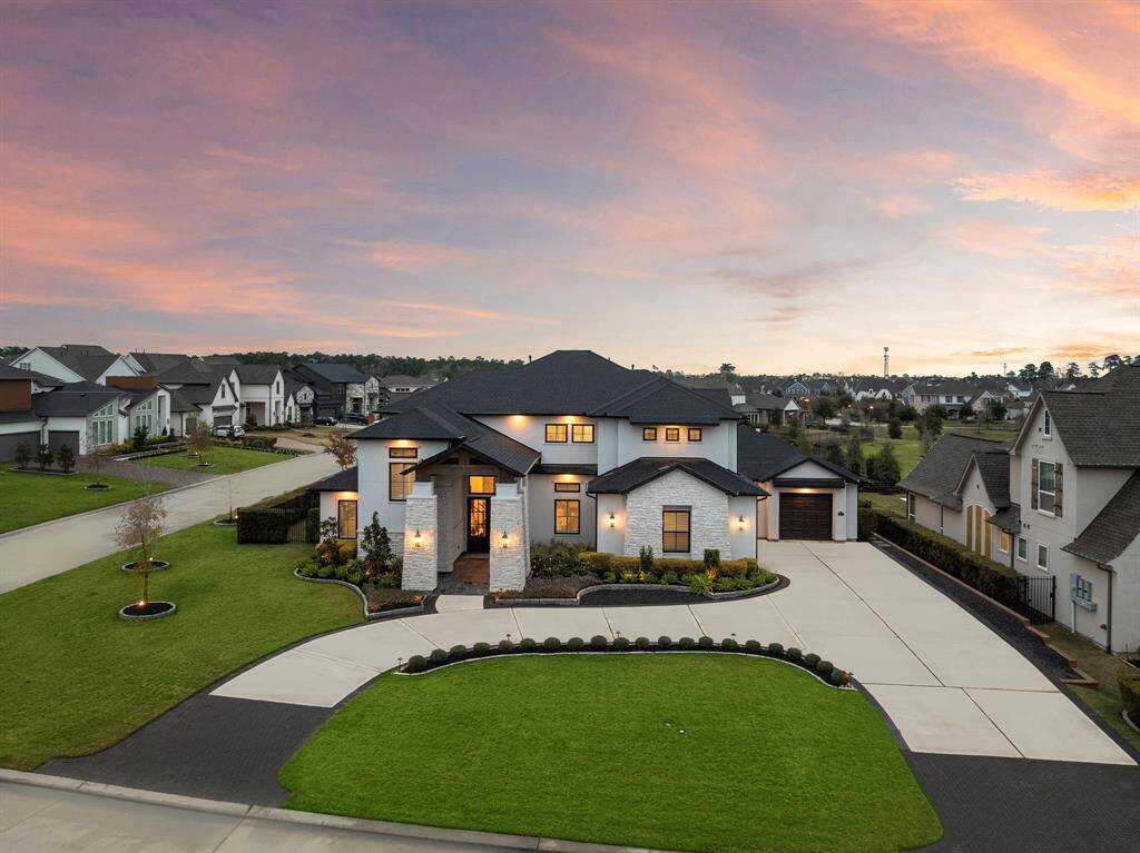 Positioned on a prominent corner lot, the home showcases its scale and symmetry while highlighting the manicured lawn and surrounding neighborhood.