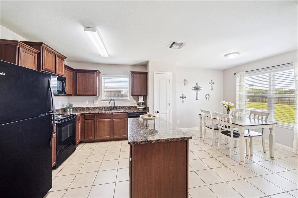KITCHEN FEATURES A CENTRAL ISLAND WITH PLENTY OF COUNTER SPACE FOR FOOD PREP!