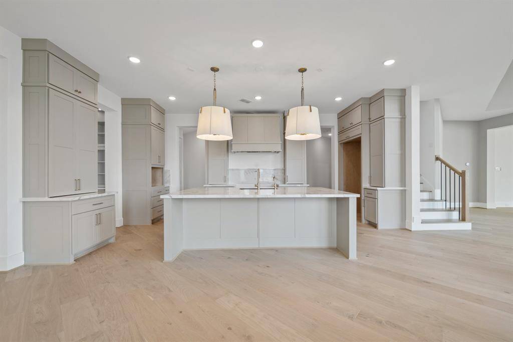 Kitchen with detailed finishes and large island, opens to the Breakfast Area and Family Room with French doors leading to the back patio perfect for entertaining indoors and out.