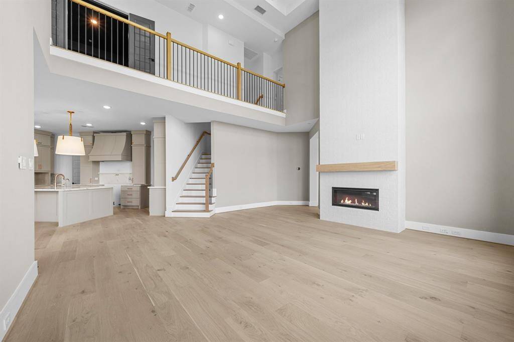 Two-story Family Room with stunning floor to ceiling stacked windows to let lots of light in with linear fireplace creating a great space to gather & entertain in off of the Kitchen, Breakfast Area, and Game Room. An additional staircase leading to the second floor is included as well.