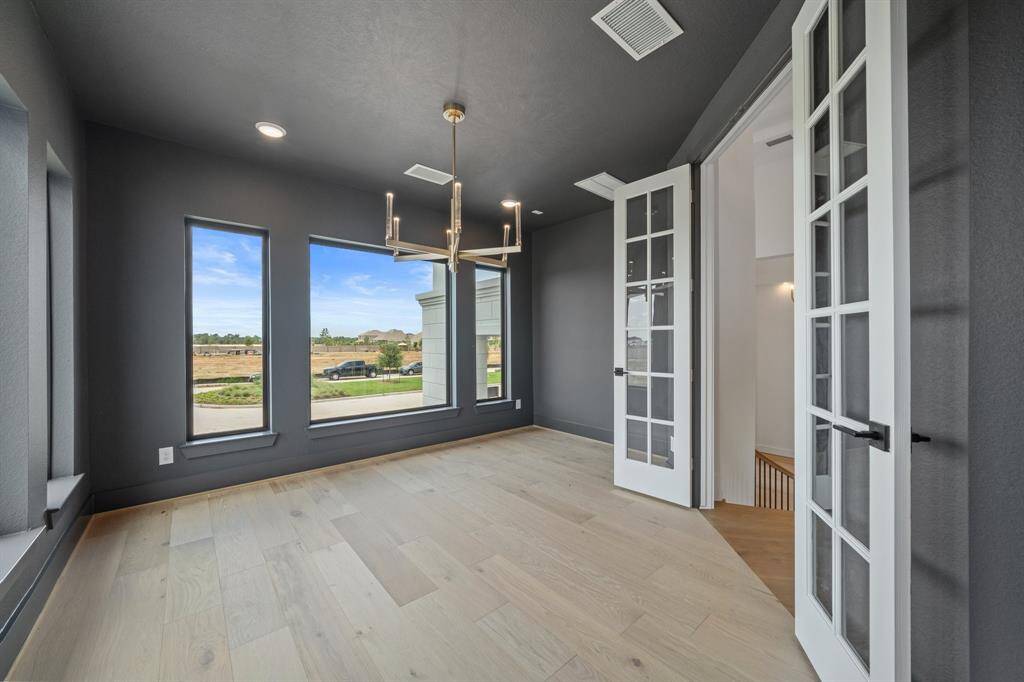 Elevated Study that's tucked away off of the curved staircase with large, clean lined picture frame windows wrapping around the room.