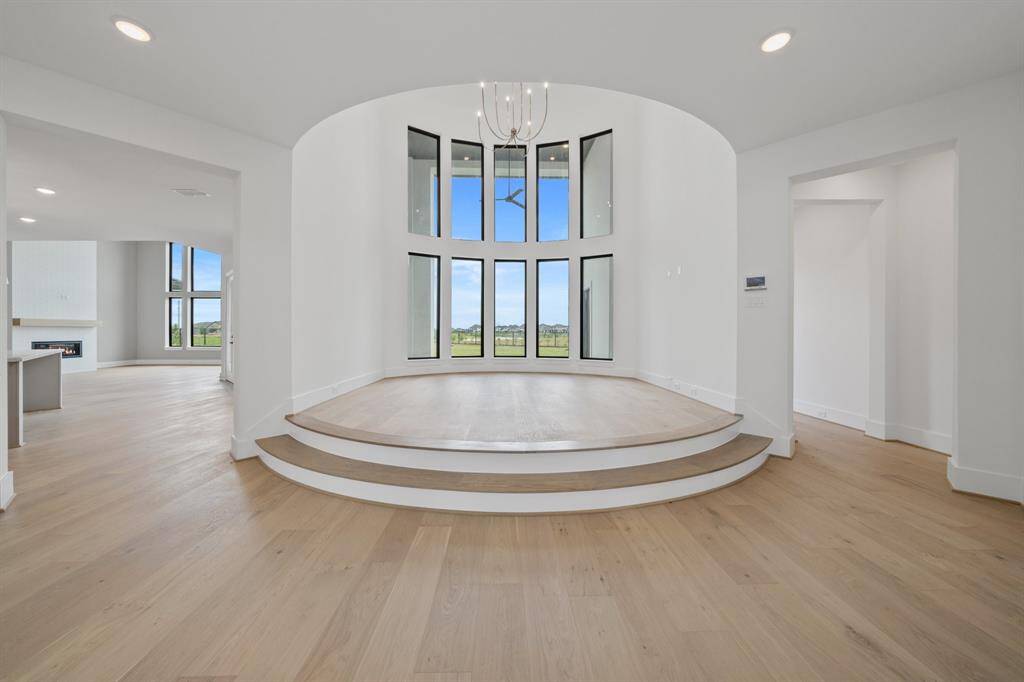 View of the exquisite, elevated Living Room with stacked windows towards the Butler's Pantry, Kitchen and Family Room that's coming along beautifully.