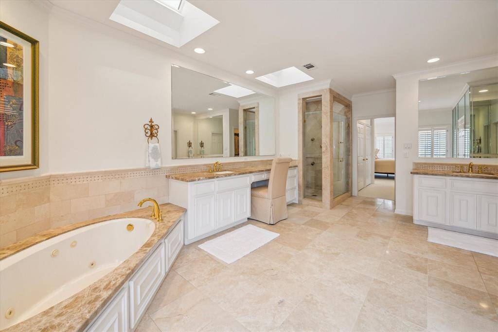 Primary Suite - Emperador light marble counters, travertine accents and flooring.