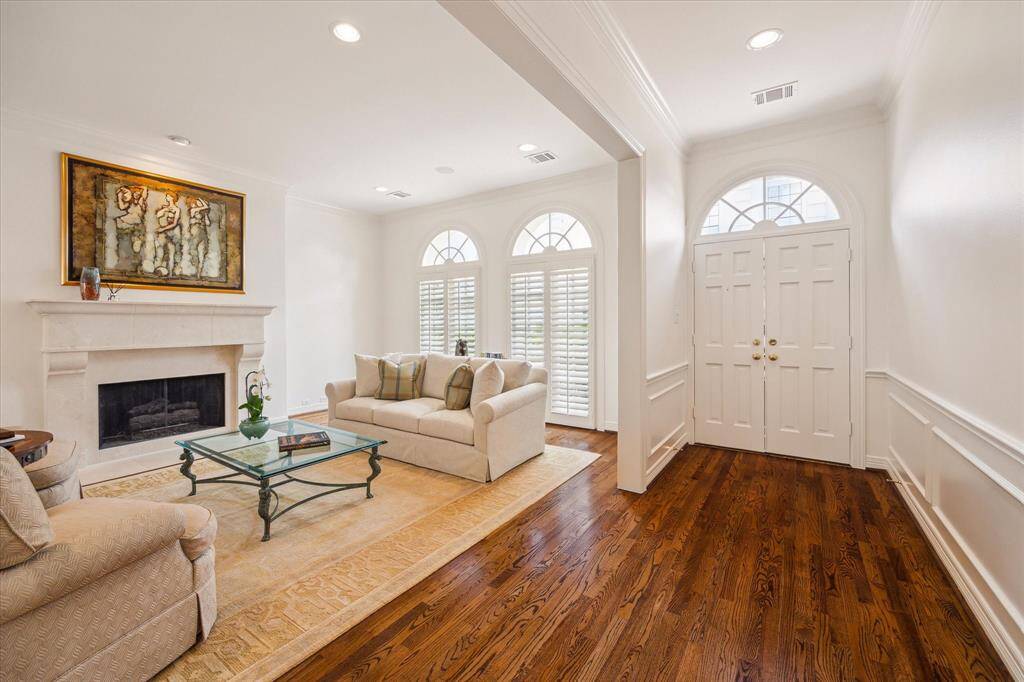 Living Room - The spacious foyer opens to a gracious living room featuring a fireplace with bespoke stone hearth and mantel from Materials Marketing, stunning oak hardwood floors, shutters on the oversized arched windows and recessed lighting.