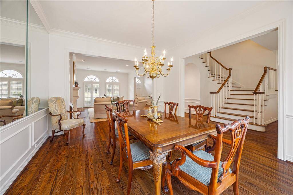 Dining Room - Flowing to both the living room and dining room effortlessly, the dining room shines with lovely crown molding, wainscoting, mirrored accent wall and gleaming hardwood floors.