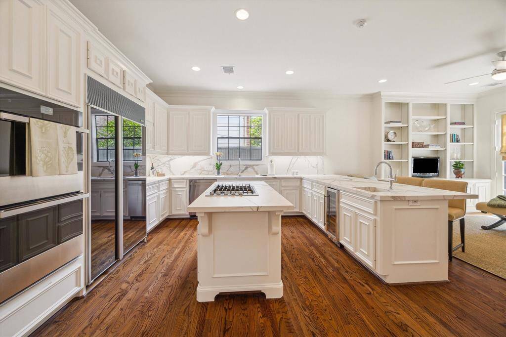 Kitchen - Italian Florimstone Elegant Gold porcelain topped counters from Thorntree set a tone of sophistication in the recently painted (2025) kitchen. Stainless steel appliances including a gas cooktop, double ovens, side by size built-in refrigerator, dishwasher and wine fridge. Note the double sinks - primary and veggie/prep.