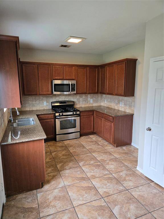 Kitchen with granite counter tops and tile backsplash