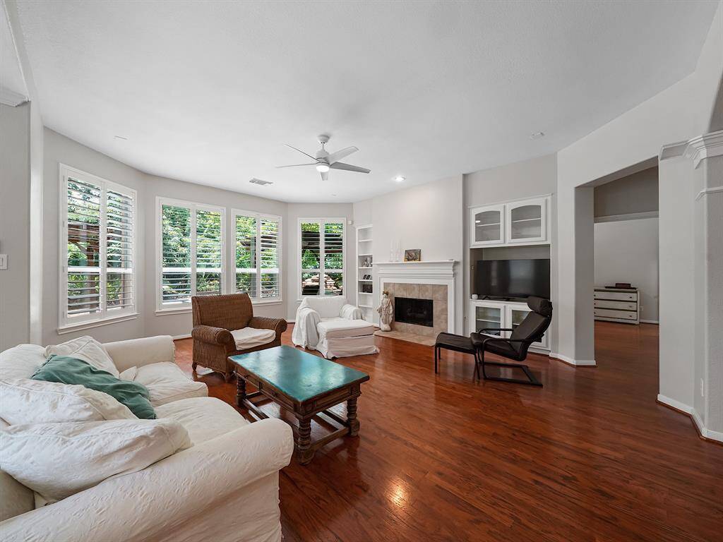 The living room boasts a sophisticated design with built-in shelves on either side of the fireplace. This thoughtfully designed space offers ample storage and display opportunities, seamlessly blending style and functionality.