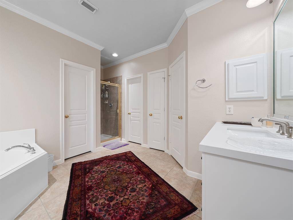 Alternative vie of the ensuite showcasing the separate shower and entrance to the walk-in closets.