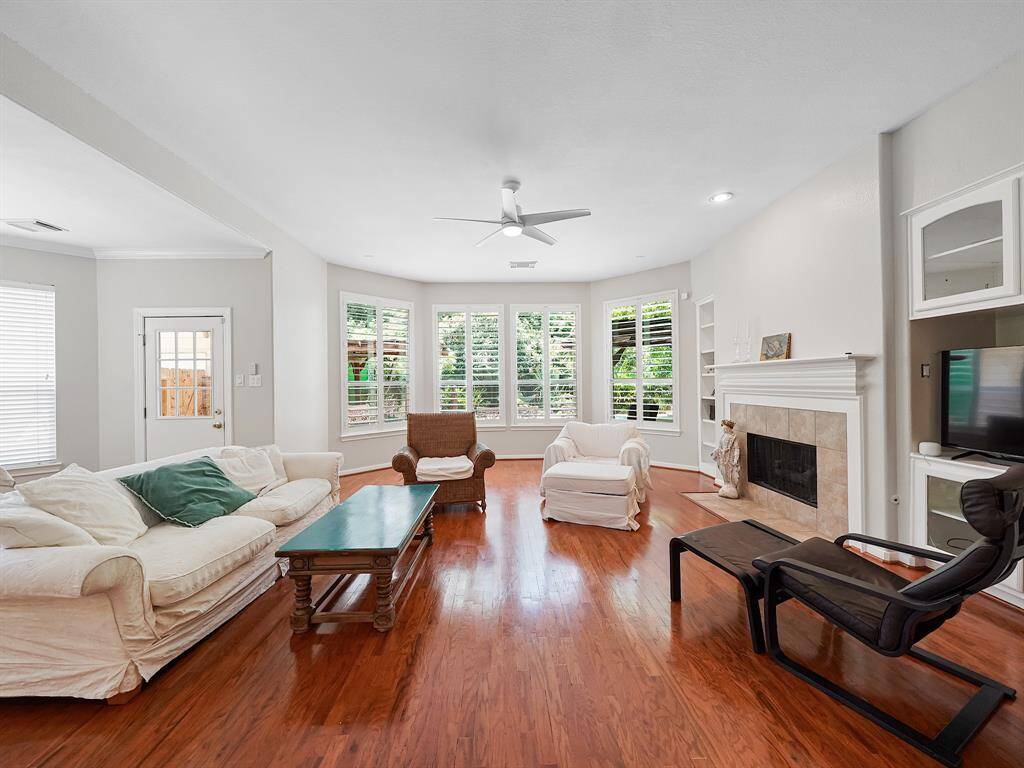 Step into a stunning living room, where a crackling fireplace creates a captivating focal point. A charming bay window floods the space with natural light and offers picturesque views of your private backyard oasis.