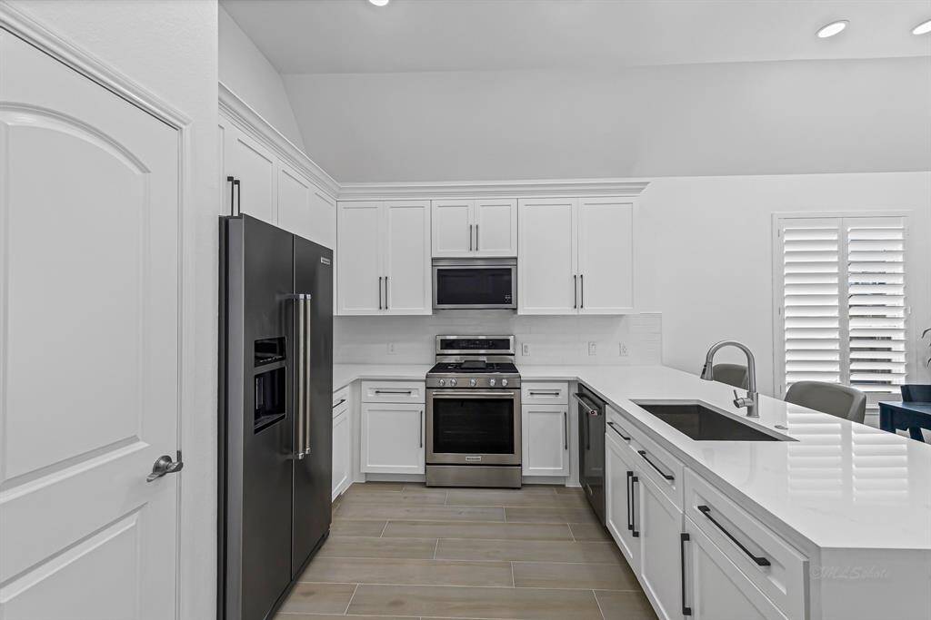 Step into this beautifully upgraded kitchen, where style meets functionality. The striking 4cm quartz countertops offer a sleek, modern look with generous workspace.