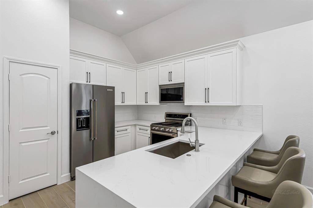 These upgraded wood kitchen cabinets are both elegant and functional, featuring crisp crown molding that adds a touch of sophistication to the space. Thoughtfully designed with plenty of storage, the cabinetry is complemented by under-cabinet lighting—perfect for highlighting the quartz countertops and creating a warm, inviting ambiance while you cook or entertain.