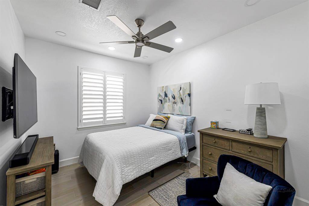 The first guest bedroom offers a serene and welcoming retreat, enhanced by fresh interior paint and soft natural light. Sleek LED lighting and a modern ceiling fan provide comfort and efficiency, while the clean lines and neutral palette create a calming atmosphere your guests will appreciate.