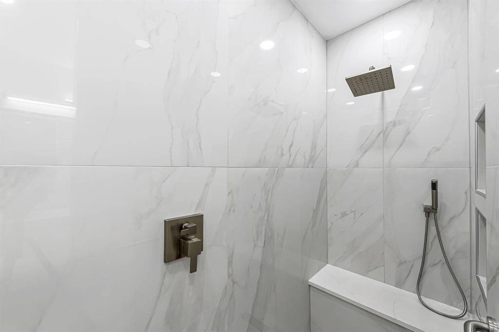 This luxurious ensuite bathroom is a true showstopper, featuring an upgraded walk-in shower with sleek tile and modern fixtures.