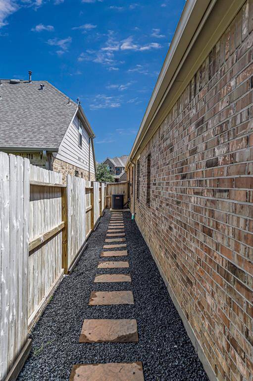 The thoughtfully maintained side yard features a clean and stylish path of pavers set in dark decorative rock, offering both charm and function. It's a low-maintenance space with easy access, perfect for utility access or simply adding a polished touch to your outdoor living.The thoughtfully maintained side yard features a clean and stylish path of pavers set in decorative rock, offering both charm and function. It's a low-maintenance space with easy access, perfect for utility access or simpl