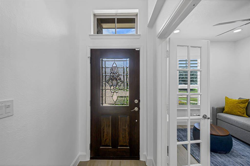 The foyer is a breath of fresh air—light, bright, and filled with natural sunshine thanks to the transom window and glass-paneled front door.