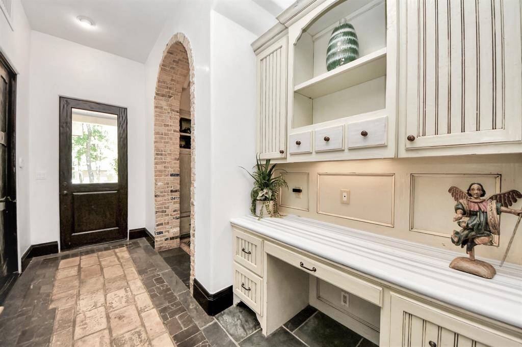 This inviting space features a built-in office next to a convenient mudroom, half bathroom, and a vibrant game room.