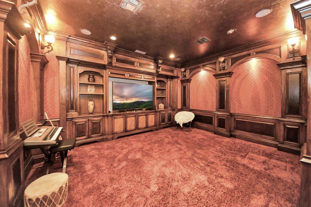 Versatile media room featuring elegant custom wood built-ins.