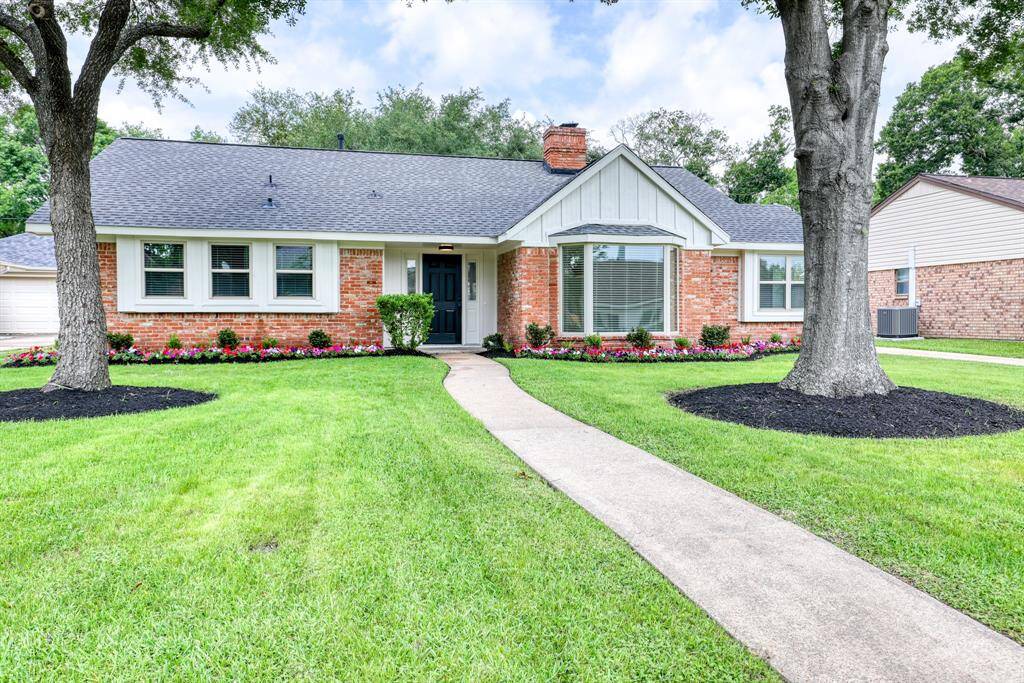 Mature trees and colorful landscaping create an idyllic front space.