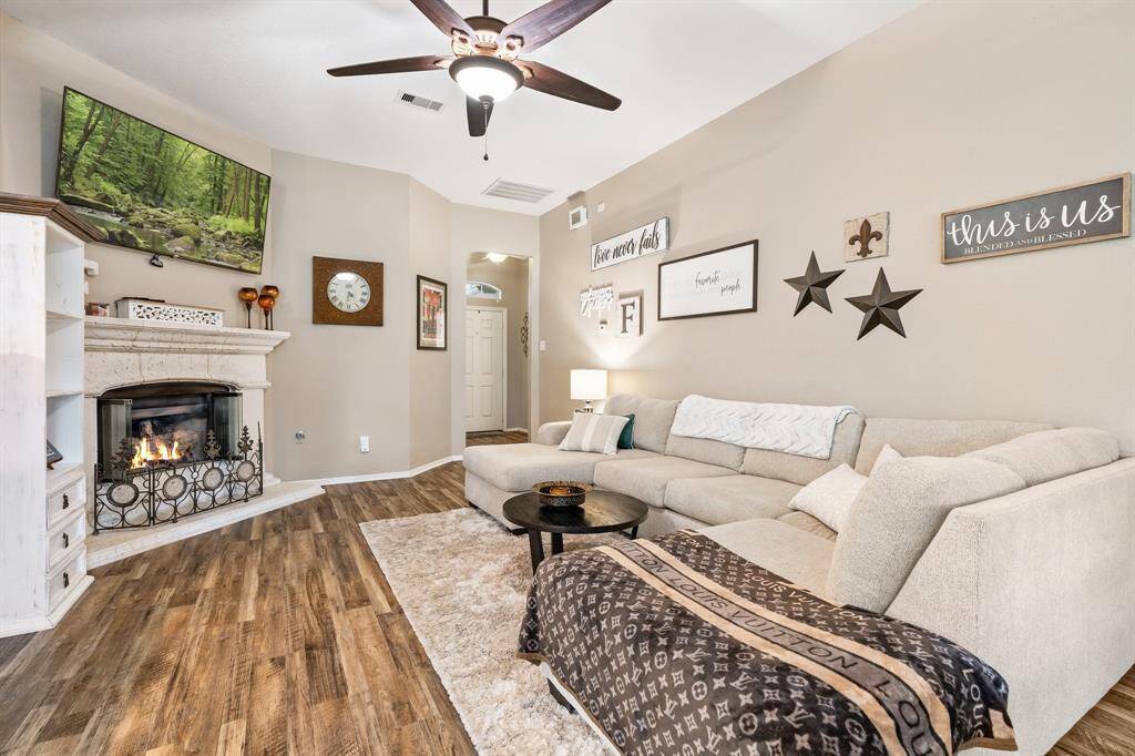 cozy up in this living room featuring a cement emcompassed gas fireplace