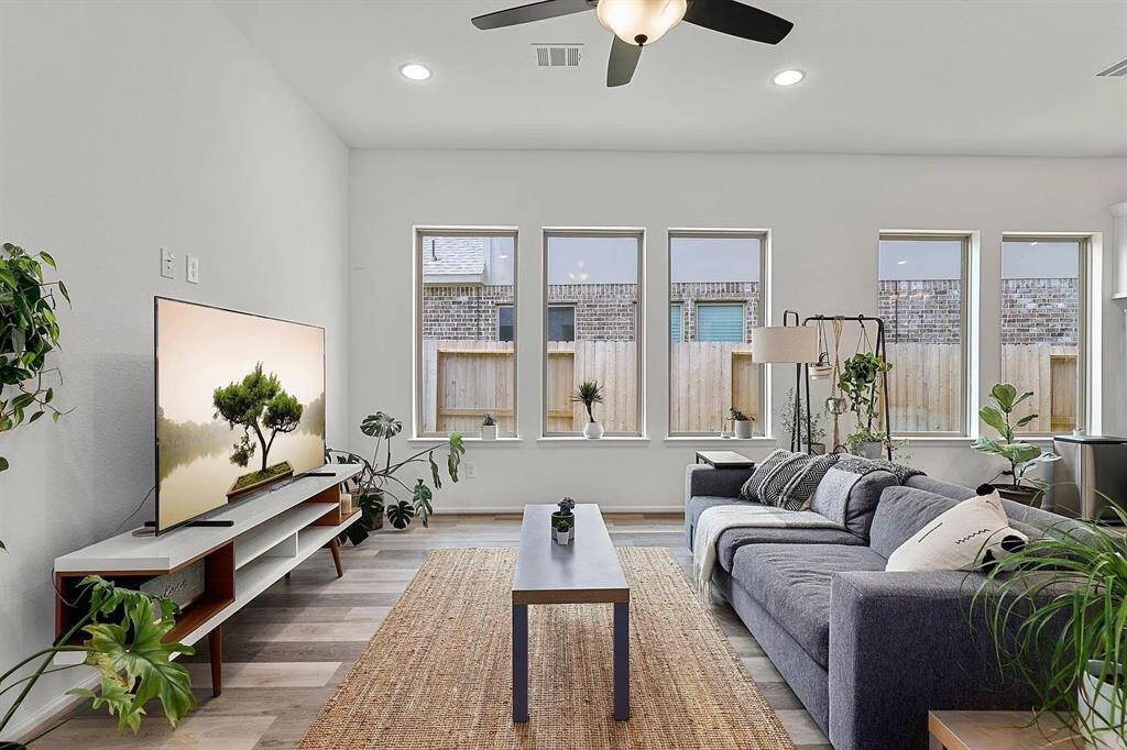 Bright living room with large windows, modern decor and airy atmosphere.