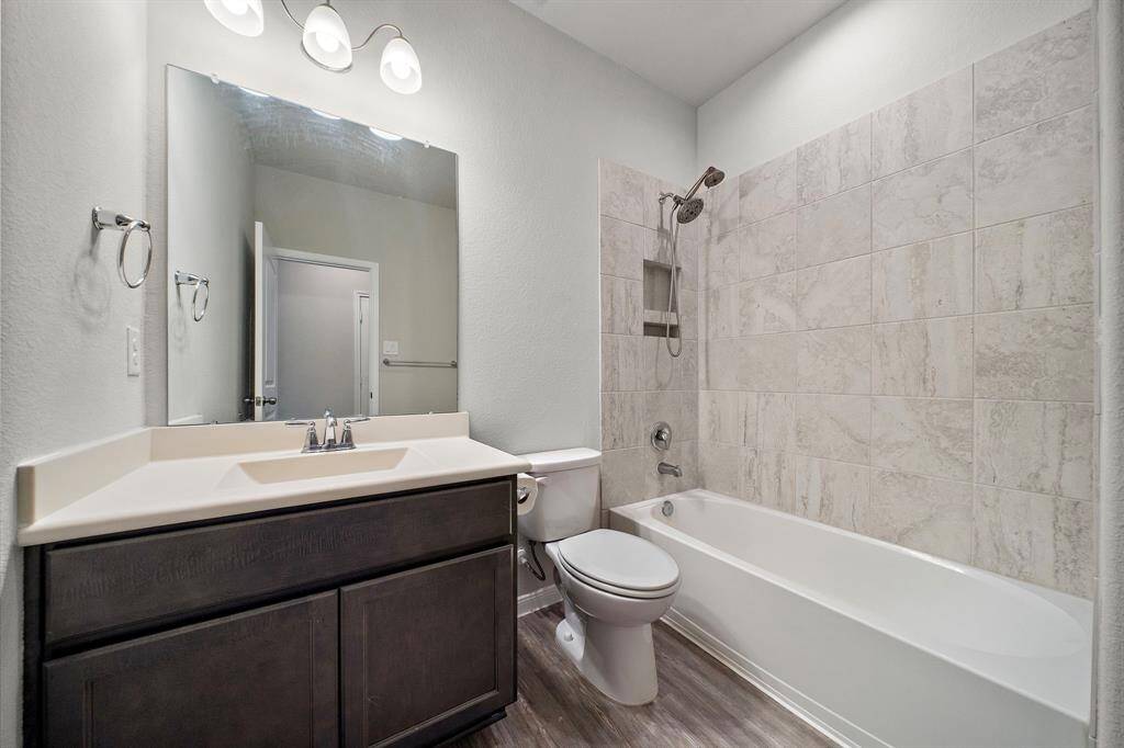 Bathroom Two, situated next to Bedroom Three, features a tub and shower combo, offering flexibility for both a relaxing soak or a quick shower. The bathroom is equipped with solid countertops, providing a sleek, modern touch to the space. This bathroom ensures convenience and privacy, making it the perfect complement to the spacious bedroom.