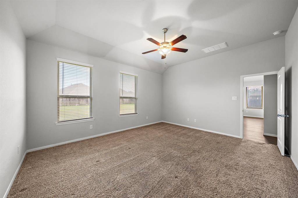 The large primary bedroom offers plenty of space, easily accommodating a king-sized bed and additional furniture. Located right off the living area, it provides easy access to the backyard, making it perfect for indoor-outdoor living. With high ceilings that add an airy, open feel, this room is a true retreat, combining comfort, style, and convenience.