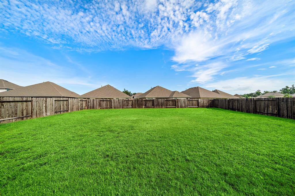 View from back of the home of the large lot and ample space in the back yard for entertaining, or playing with the  kids.