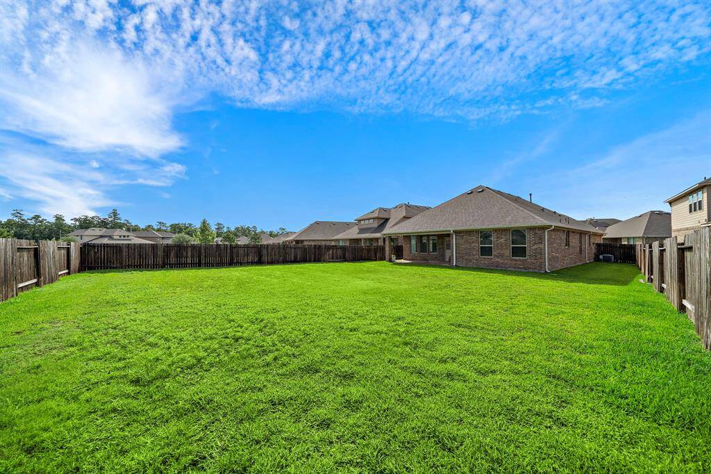 View from the back of the fence towards the home with views of the spacious side yard as well.