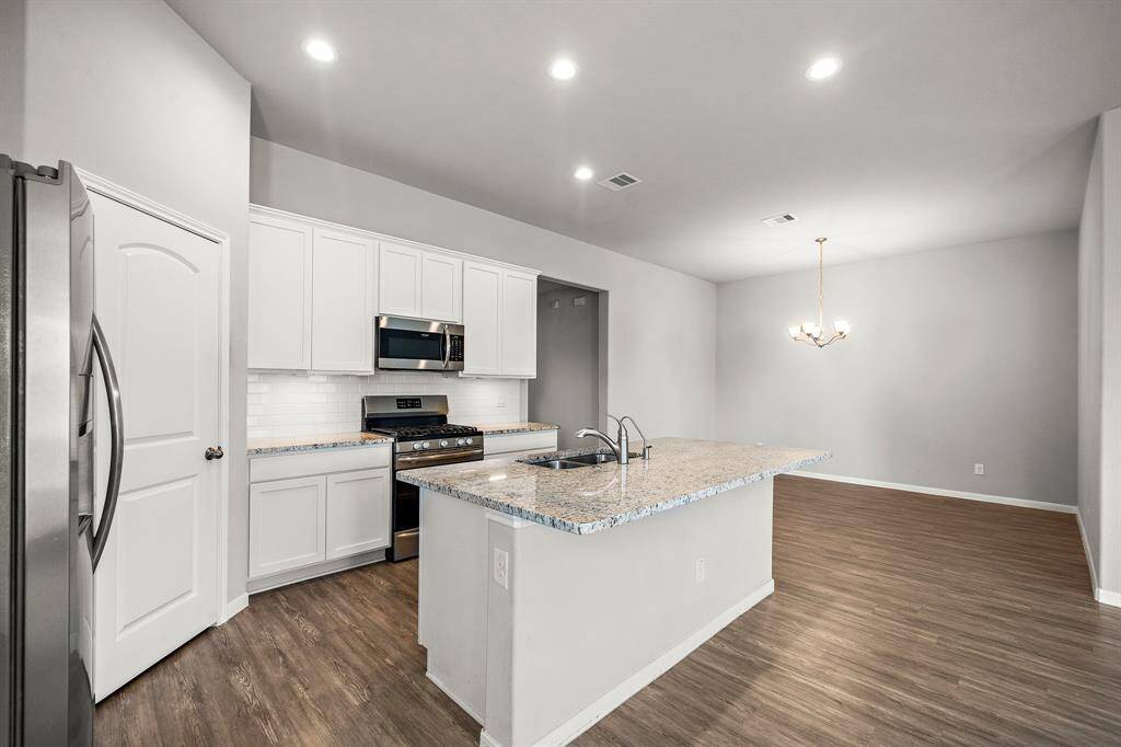 Step into the spacious kitchen, perfect for entertaining guests or preparing family meals. This kitchen boasts generous counter space, modern appliances, and plenty of cabinets for storage. A fridge is included, making move-in even easier.