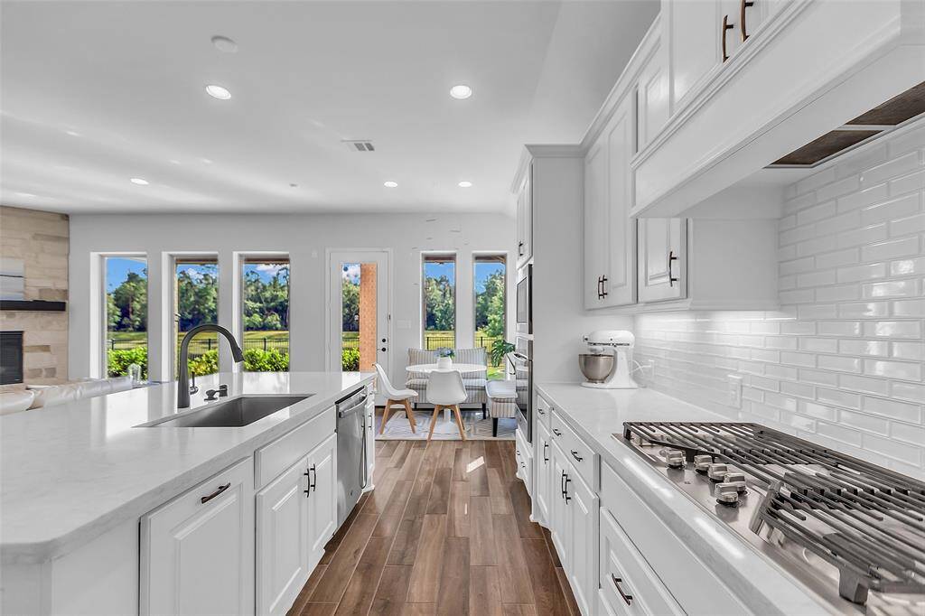 The kitchen is designed to inspire culinary creativity and cherished moments alike. Its white cabinetry stretches generously throughout the space, offering ample storage while enhancing the kitchen's bright and airy ambiance.  Stainless appliances, including convection oven, gas cooktop and farmhouse sink add another touch of elegance along with quartz countertops, white subway tile and sleek hardware.  A true jewel of the home, this kitchen effortlessly combines practicality with stunning aesthetics.