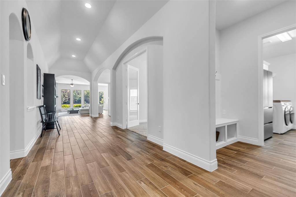 As you proceed through the entry hallway, you will notice the utility area featuring a built-in hall tree, which is ideal for hanging coats, backpacks, umbrellas or storing shoes. This design facilitates easy organization of daily essentials for convenience when entering or leaving.