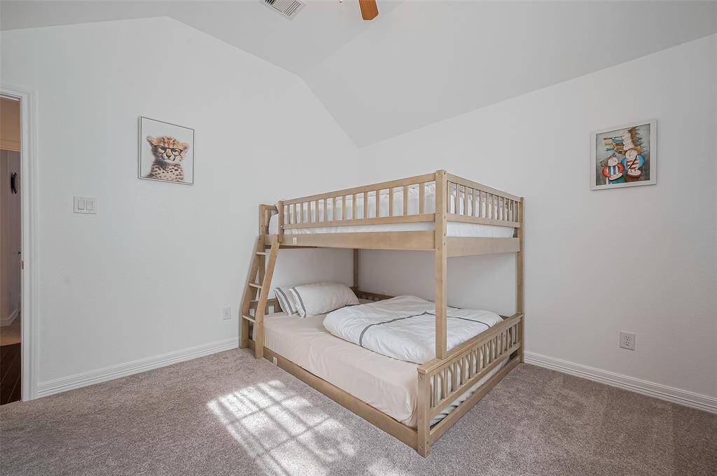 This carpeted bedroom is defined by clean lines and generous dimensions that lend both warmth and function.