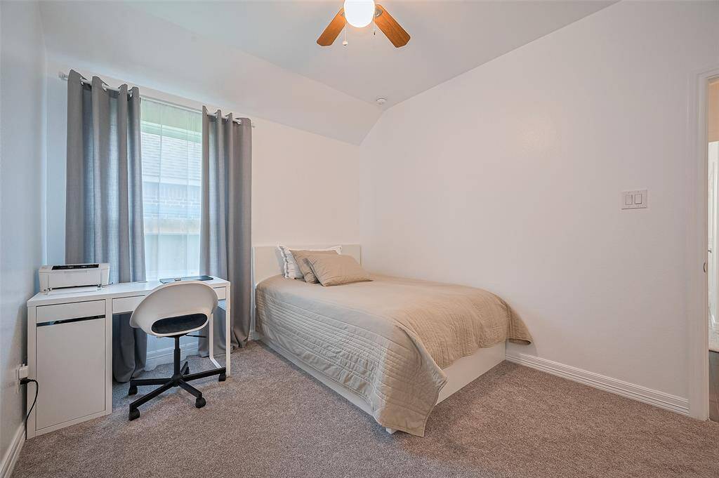 With plush carpeting for quiet comfort and outfitted with a large window and ceiling fan, this bedroom creates a space for rest, creativity, or both.