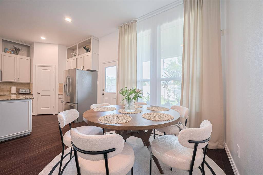 Set in a sunlit corner beside an oversized window, the dining area feels both grounded and elevated—a perfect place to linger over meals or morning routines.