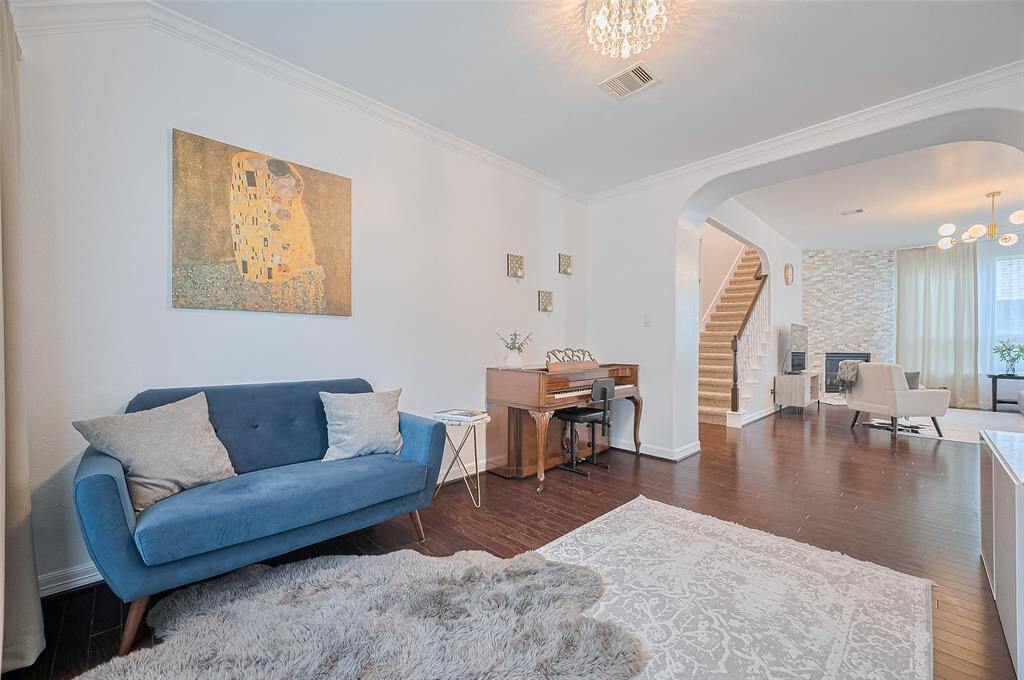 Across the living area, this flexible space could host conversation, creativity, or quiet retreat. Sunlight filters in through large windows, making the space feel both distinct and connected.