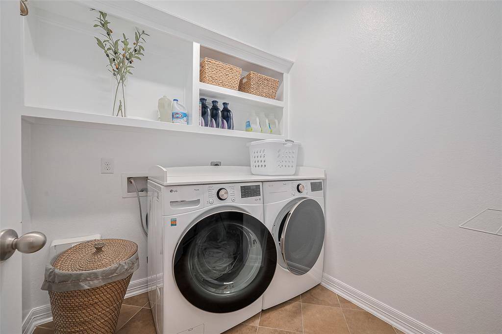 More than utilitarian, this laundry space is thoughtfully designed with open white shelving that keeps essentials organized and accessible.