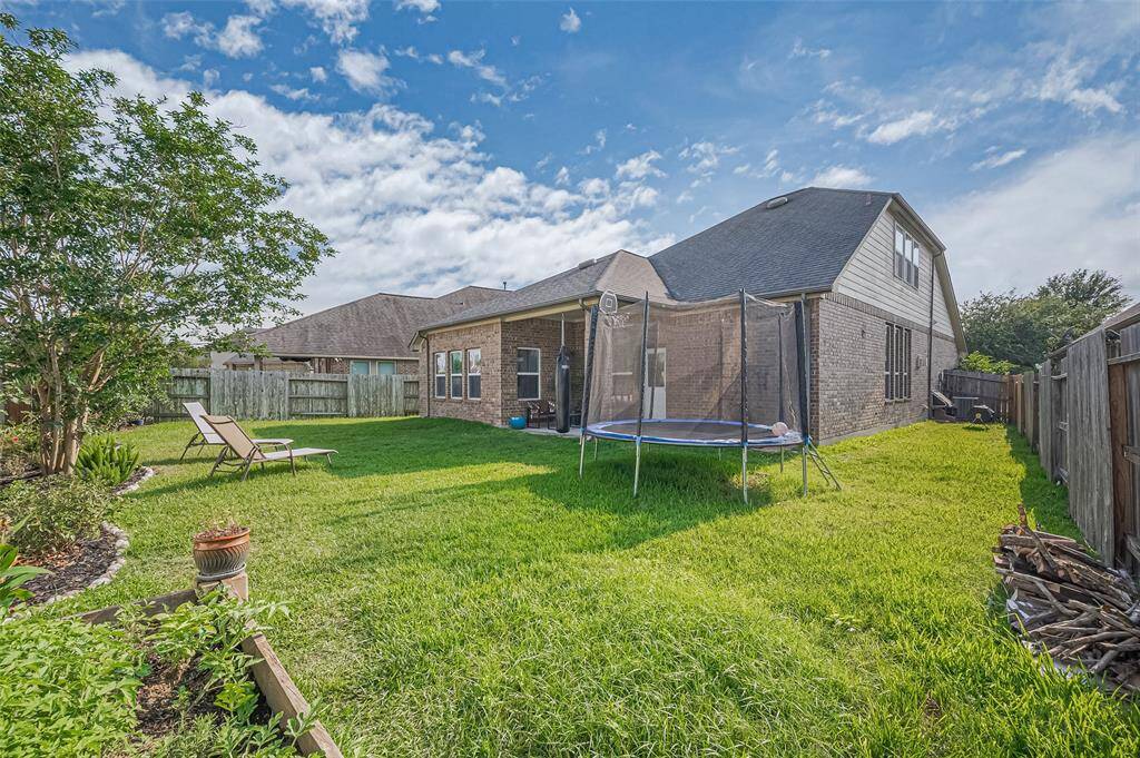 With young trees, flourishing garden beds, and a wide stretch of green, the backyard is a blank canvas ready for play, planting, or quiet contemplation under the Texas sky.