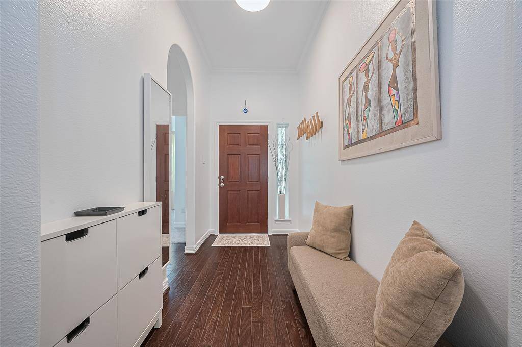 Inside, the crisp white palette and dark wood flooring offer a quiet contrast, immediately establishing a sense of calm and clarity upon entering.