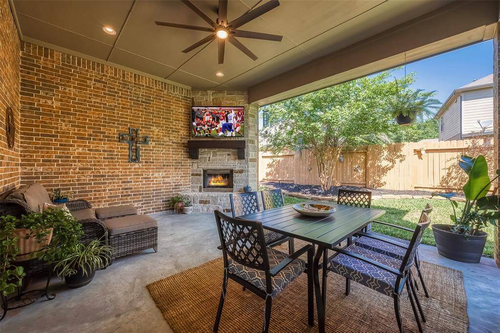 Spacious covered patio with wood-burning fireplace (with gas lighting starter).  Brand-new large fan provides ample airflow for those hot summer days.  TV stays.  Option to leave all furniture pictured.