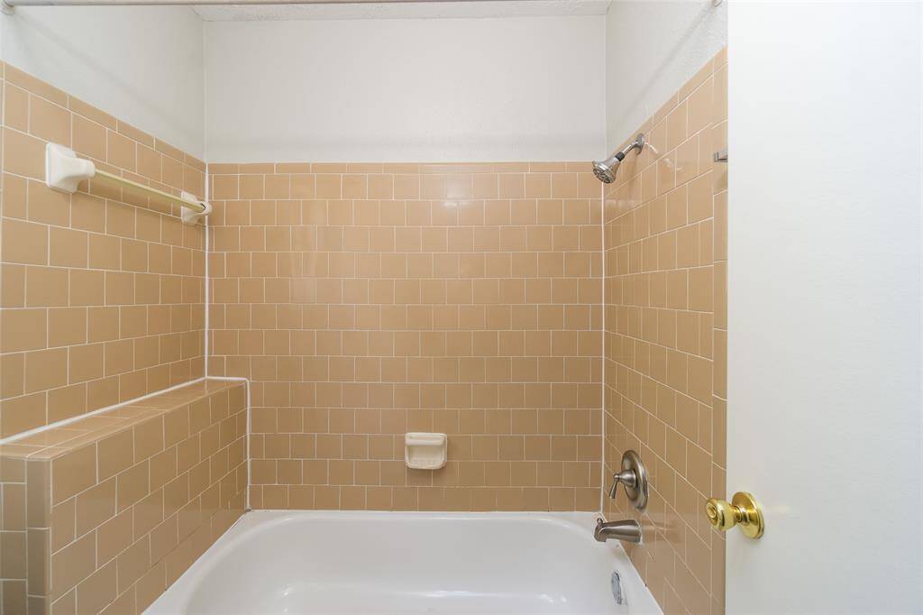 Fully tiled tub/shower combo in the primary bath