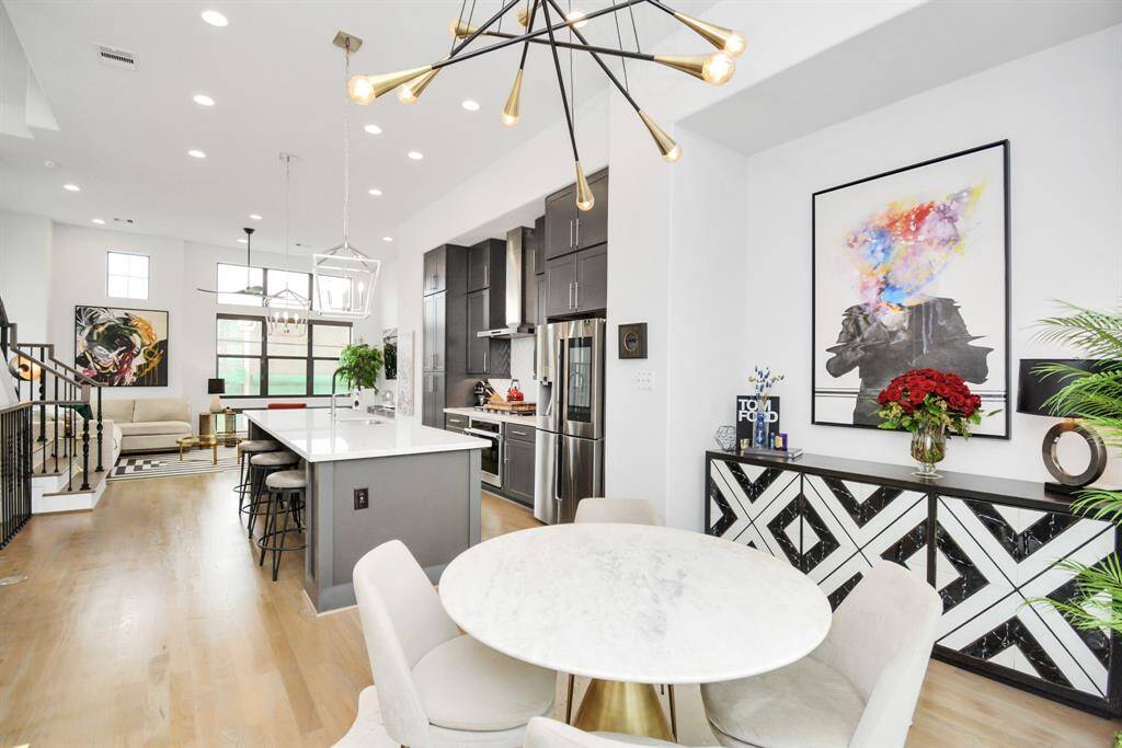 Ideal for entertaining, this open-concept dining, kitchen, and living area offers seamless flow. *(Note: Dining light fixture not included.)*