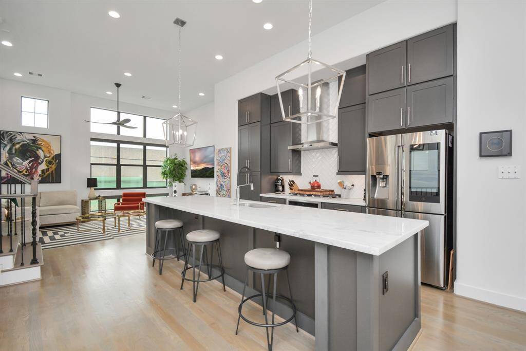 Experience elevated living with 12-ft ceilings and a stunning 12-ft marble island, complete with a refrigerator and built-in beverage cooler.